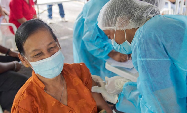 Trabajador de salud vacunando a una mujer