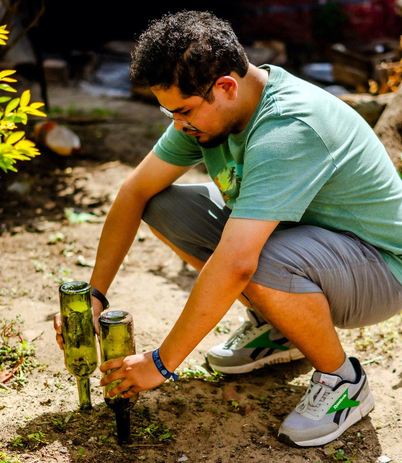 Health worker shows how to store empty bottles so they won't collect water, in the fight against dengue and other mosquito-transmited diseases