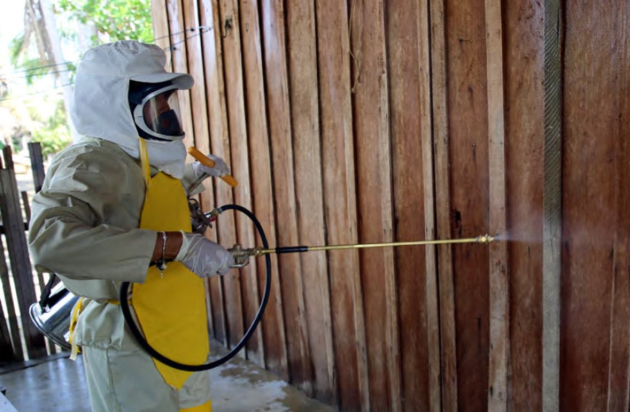 Man fumigating a home with inseticide against the malaria mosquito