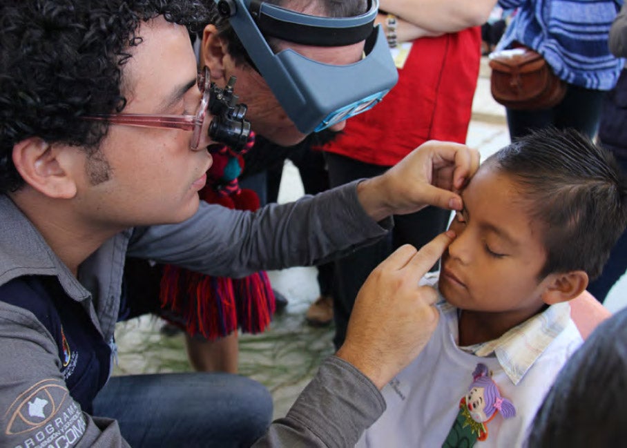 Health worker examines the eyes of a girl