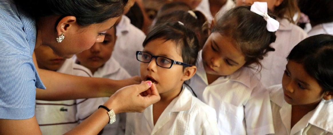 Young girls being vaccinated at a school in Latin America