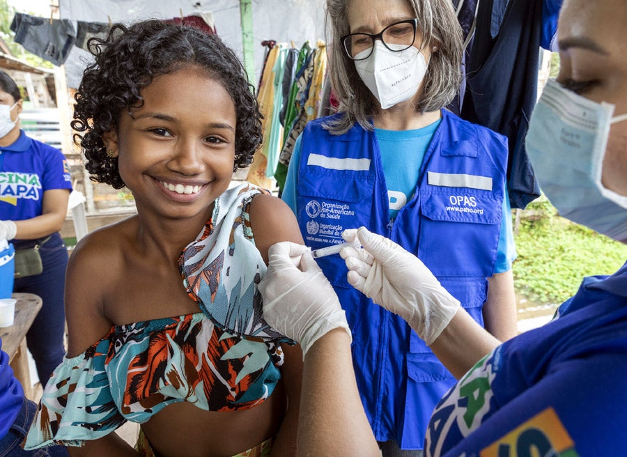 Trabajadora sanitaria vacuna a una niña en Brasil