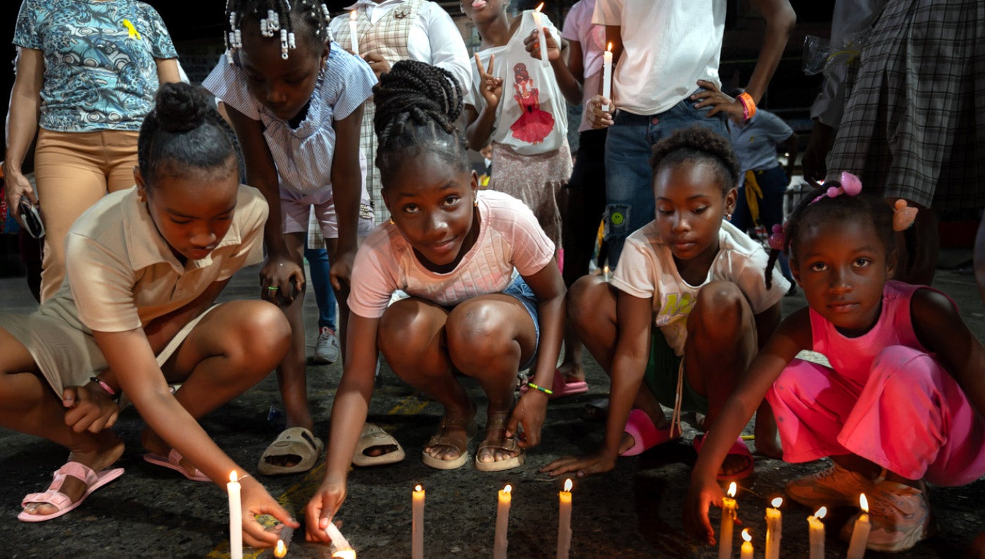 Caribbean girls lighting candles