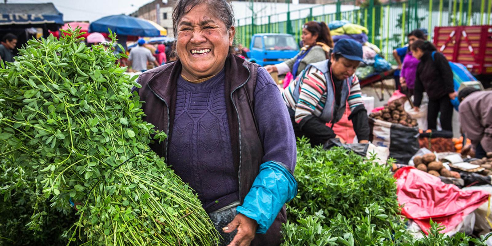 mujer vendiendo verduras en un mercado